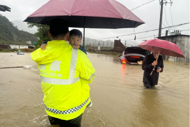 民警将高烧宝宝裹在怀里 蹚过及腰积水送医 台风暴雨中紧急救援